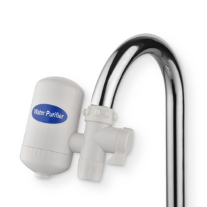 filtro purificador de agua cromado instalado en un grifo de cocina moderno filtrando agua cristalina hacia un vaso.