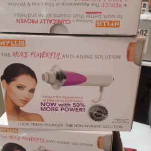 dispositivo tonificador facial anti envejecimiento color blanco con cabezales de microcorriente aplicándose sobre el pómulo para definir el contorno facial.