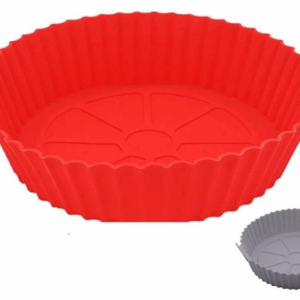 canasta de silicona roja para air fryer con diseño circular y ranuras para circulación de aire sobre una encimera de cocina.